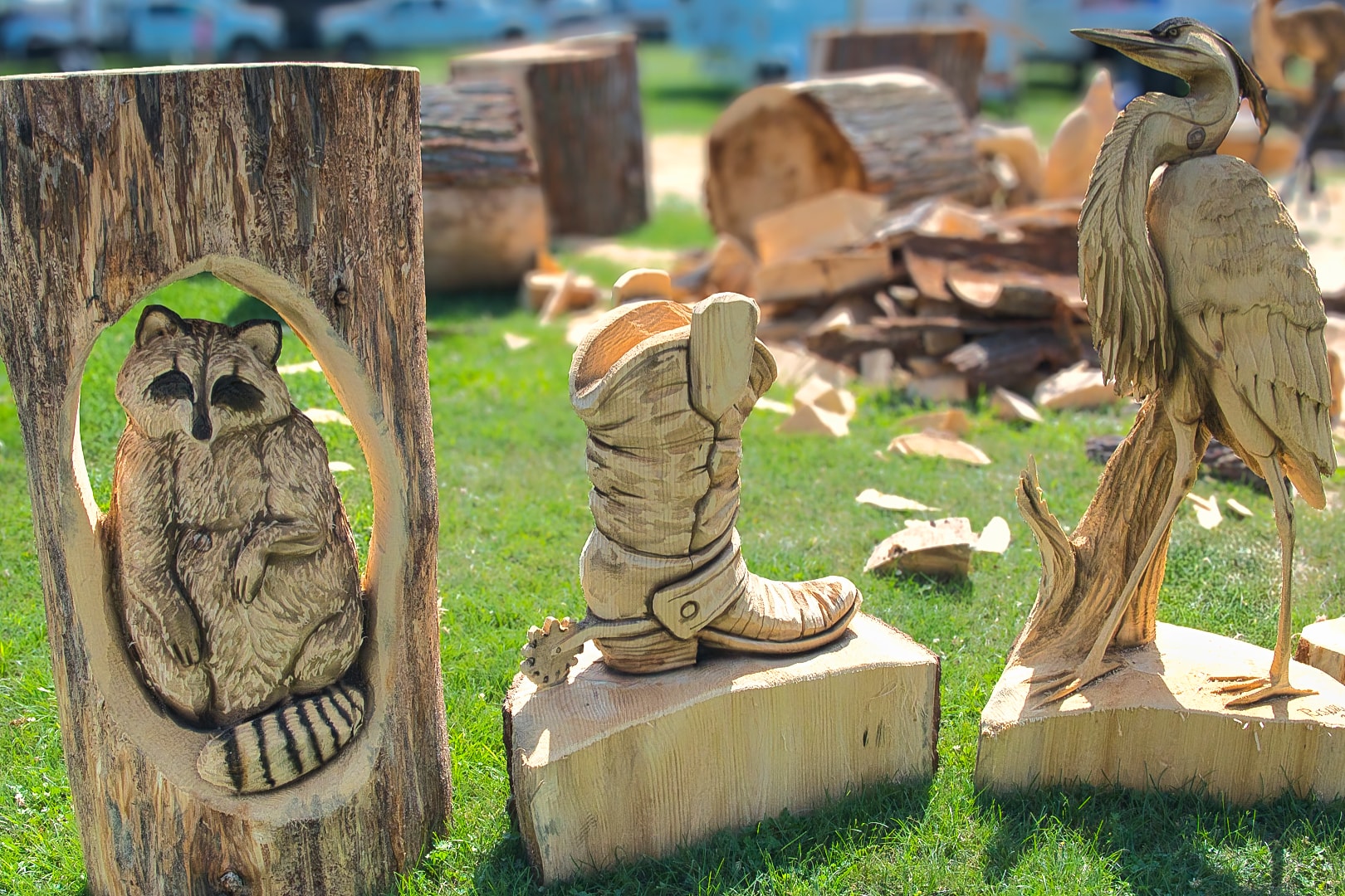 Chainsaw carvings — raccoon, cowboy boot, and heron — at the St. Clair County 4-H Fair