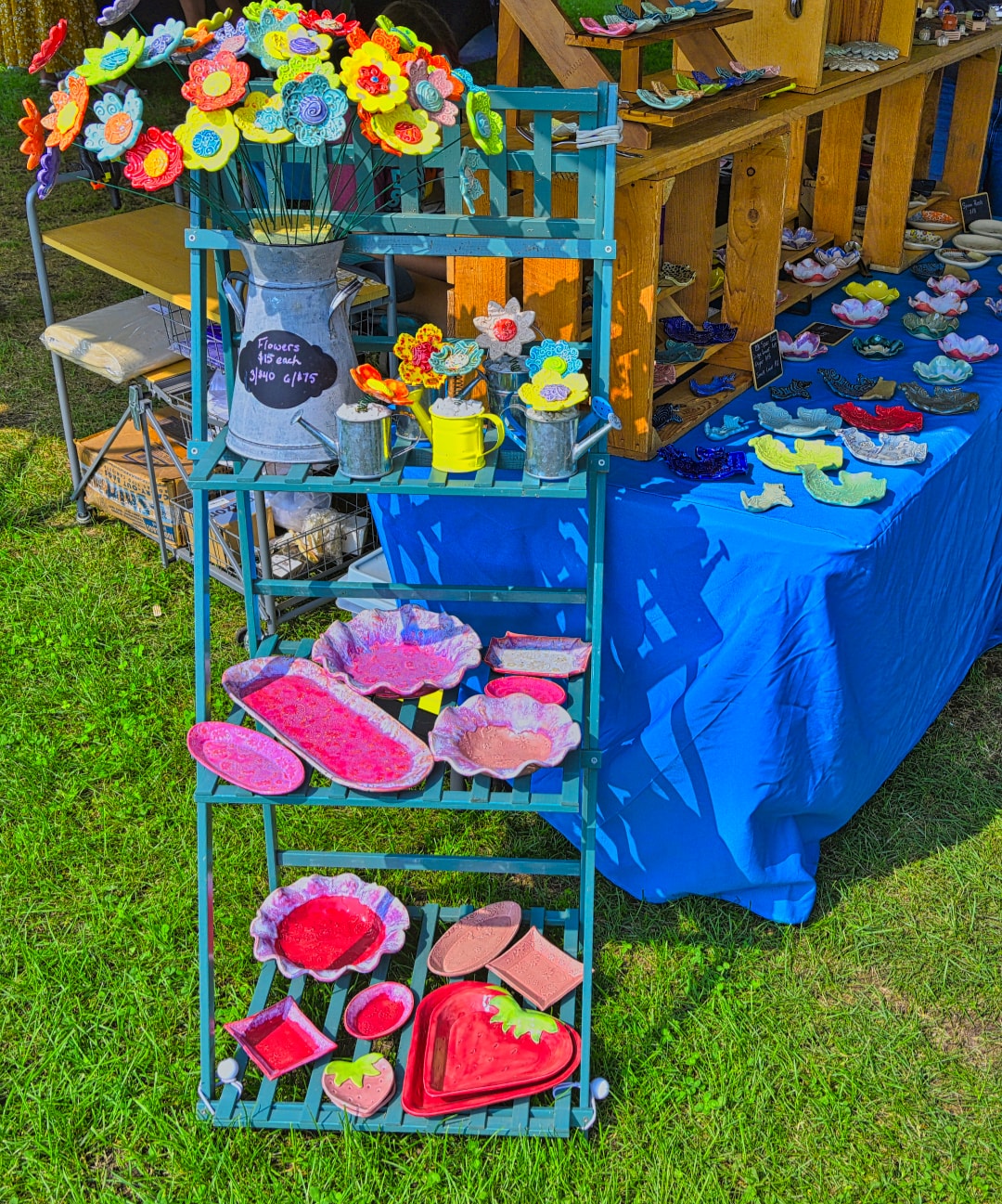 Colorful handmade ceramic flower sculptures and glazed pottery dishes displayed at a vendor booth at Blake's Lavender Festival, Armada Michigan — festival craft and product photography by Atelier Lens LLC