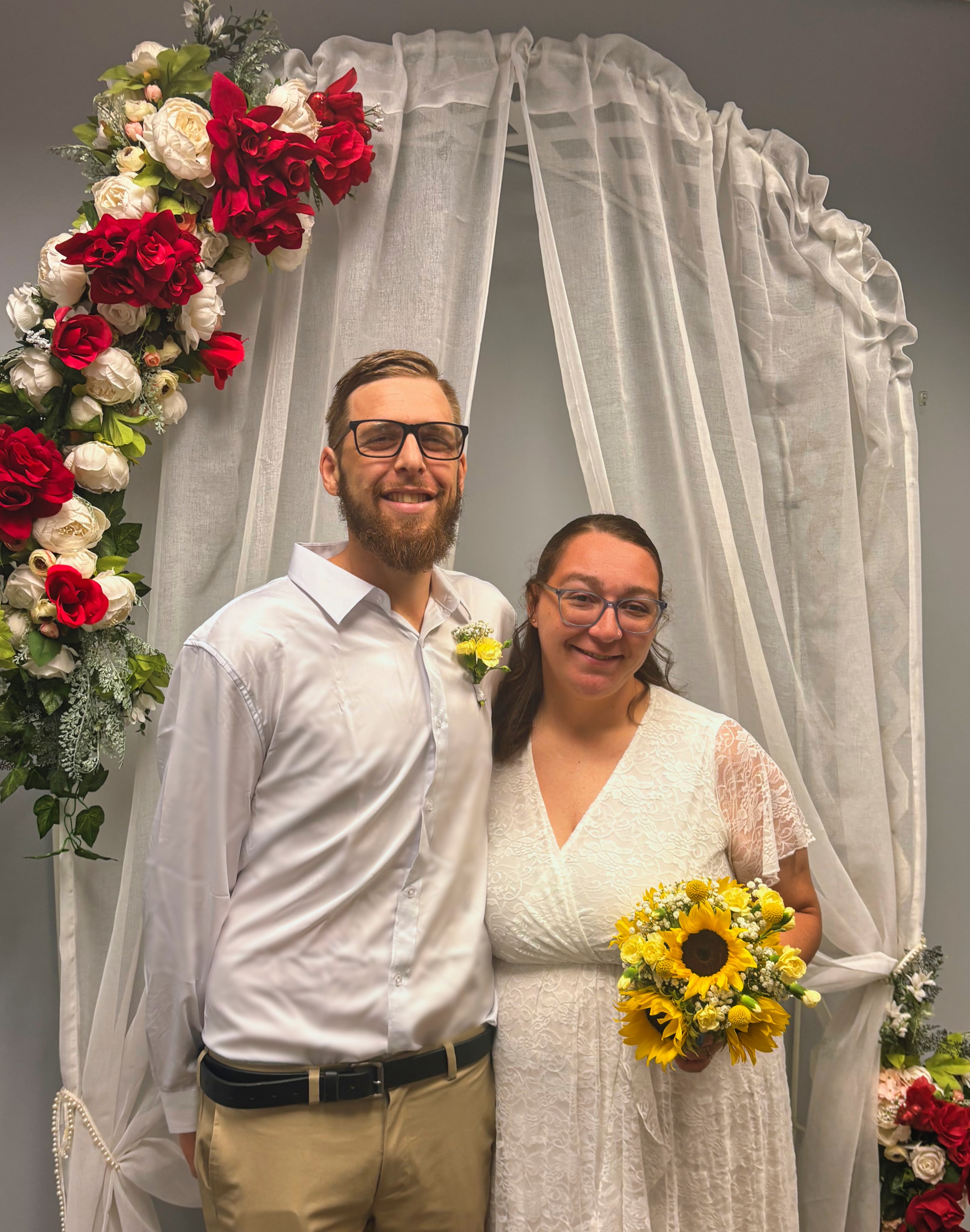 Couple at their wedding arch with a sunflower bouquet — Atelier Lens LLC, New Baltimore